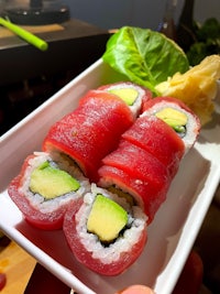 a plate of sushi with tuna and avocado on it